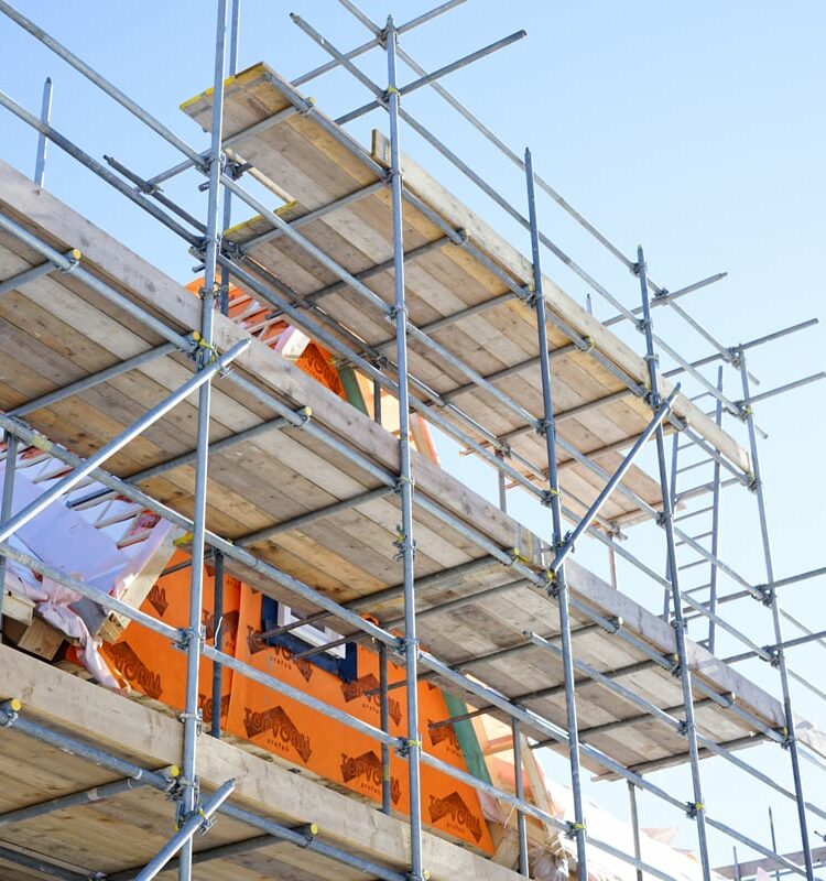 Das Bild zeigt eine Baustelle, Haus mit Baugerüst und dient als Beitragsbild der Seite zum öffentlichen Baurecht.